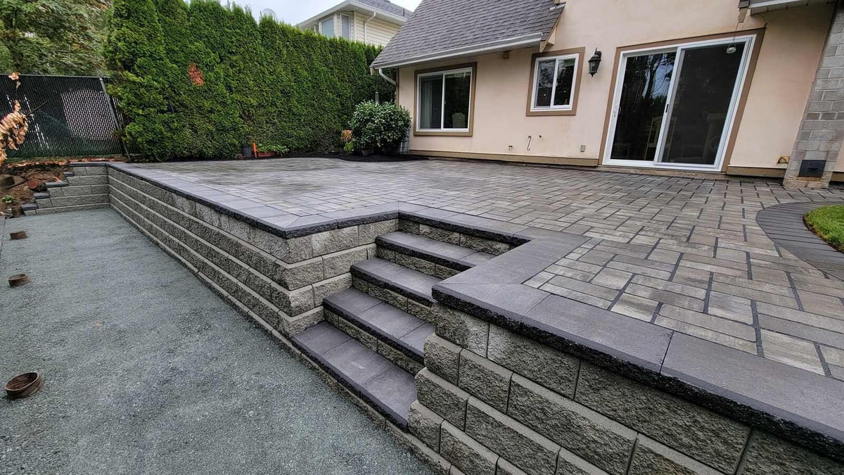 26_Beautifully landscaped backyard with tiered patio, pavers, and greenery by Back40 Landscaping in Abbotsford, BC