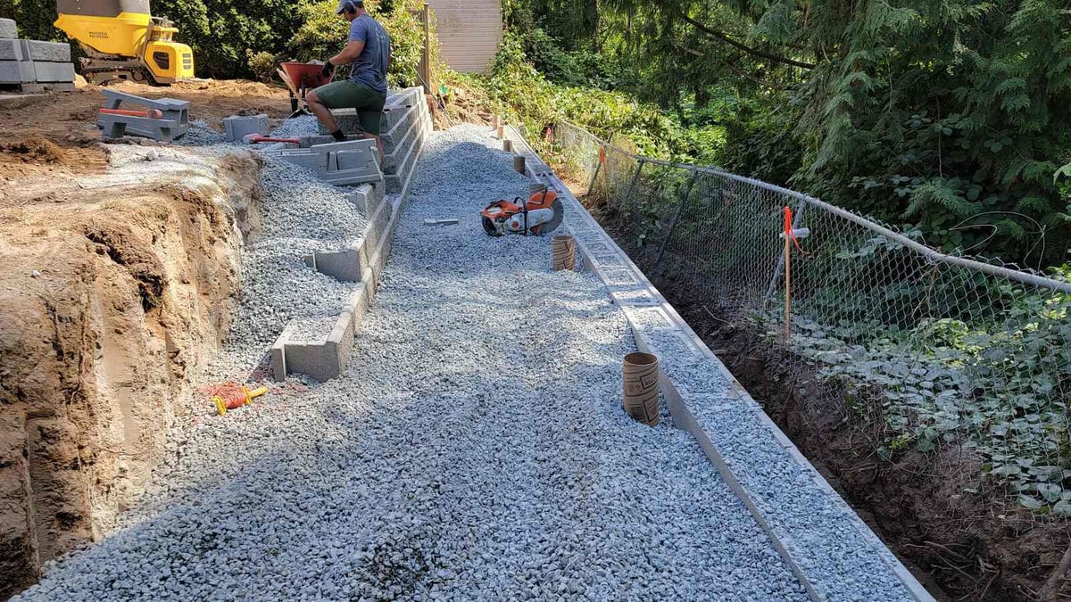 8_Worker installing blocks for a retaining wall in Abbotsford, BC, as part of Back40 Landscaping’s project