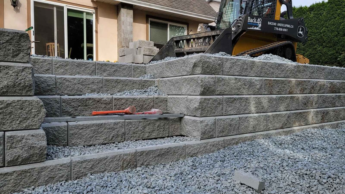 9_Stacked retaining wall blocks with gravel on a landscaped slope in Abbotsford, BC, by Back40 Landscaping