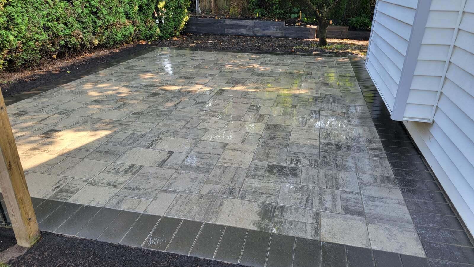 Residential concrete paver patio with a polished finish and contrasting border by Back 40 Landscaping in Abbotsford, BC