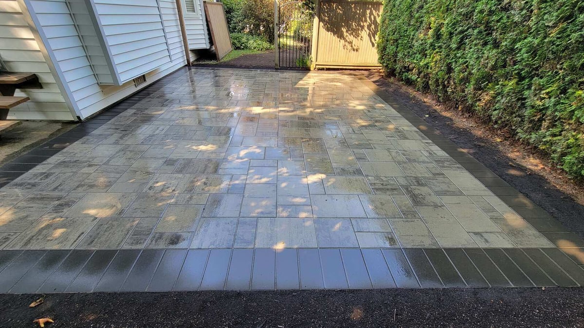 Sunlit concrete paver patio with a smooth finish by Back 40 Landscaping, Abbotsford, BC