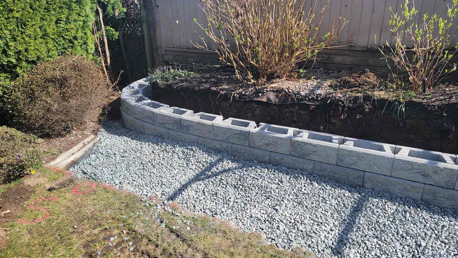 7_retaining-wall-project-back40-landscaping-burnaby-bc-initial-retaining-wall-blocks-placed-along-curved-layout
