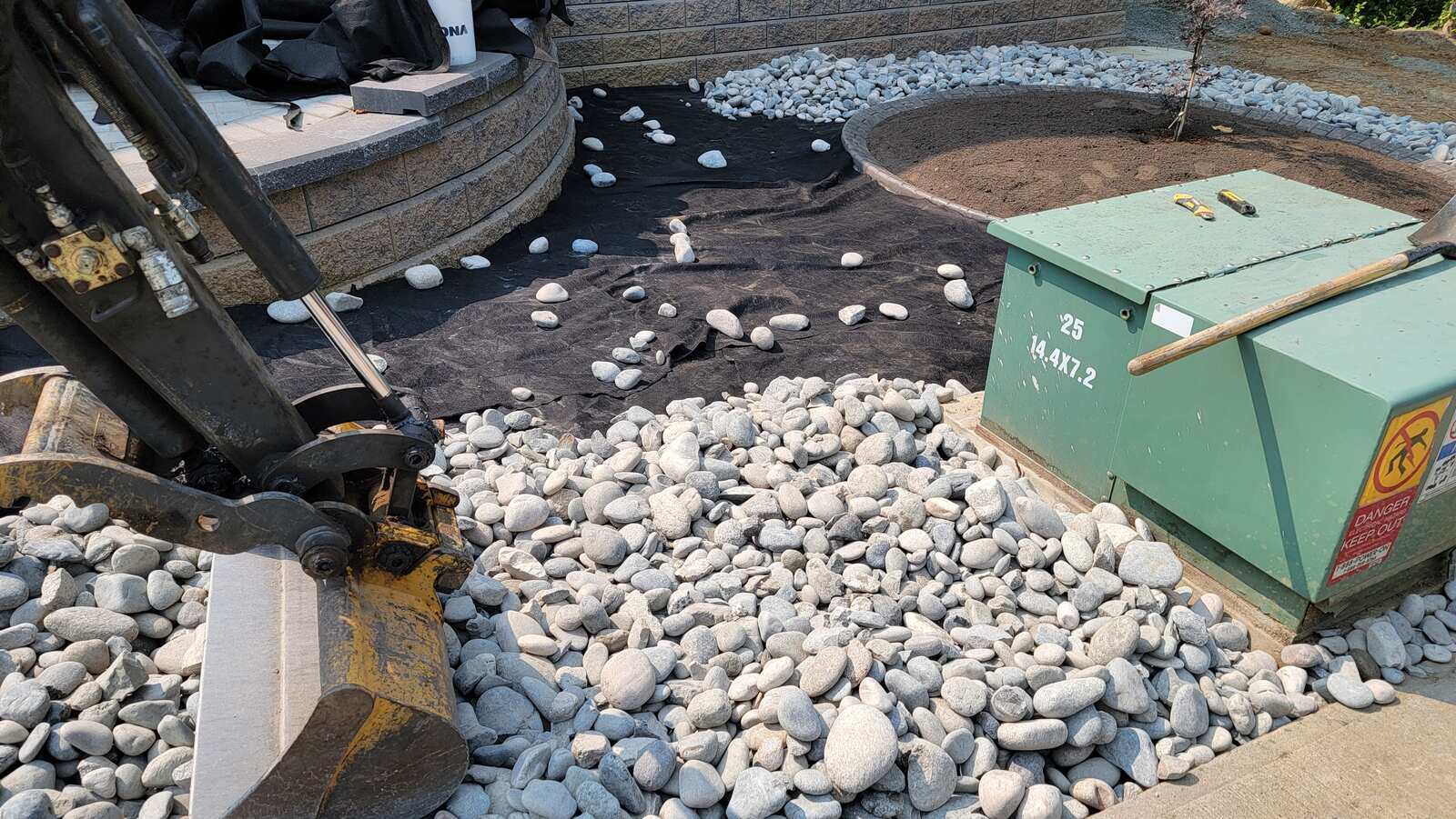 13_installation-of-landscape-fabric-and-river-rock-with-equipment-in-chilliwack