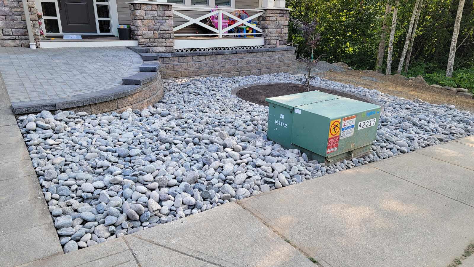 15_completed-landscaping-with-stone-retaining-wall-paver-patio-and-river-rock-in-chilliwack