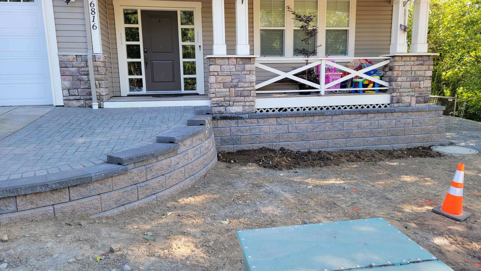 9_completed-curved-retaining-wall-with-stone-finishing-and-clean-paver-patio-in-chilliwack