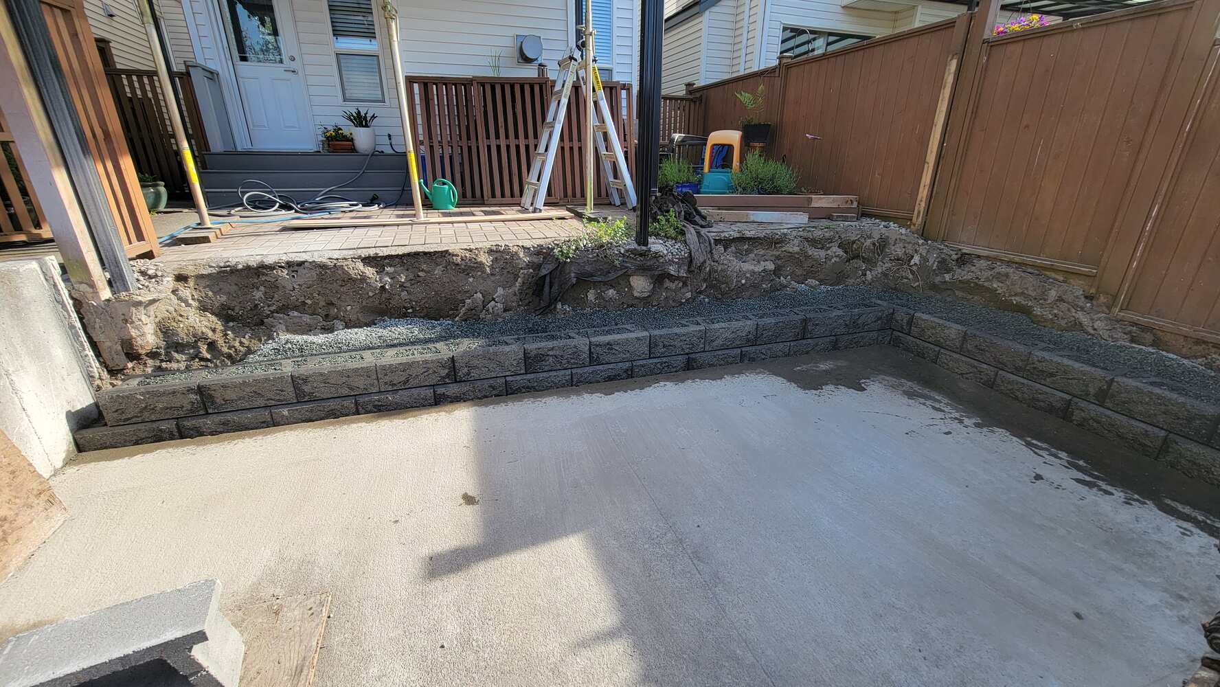 8_partially-built-retaining-wall-with-backfill-material-and-excavator-on-site-back40-landscaping-langley-bc