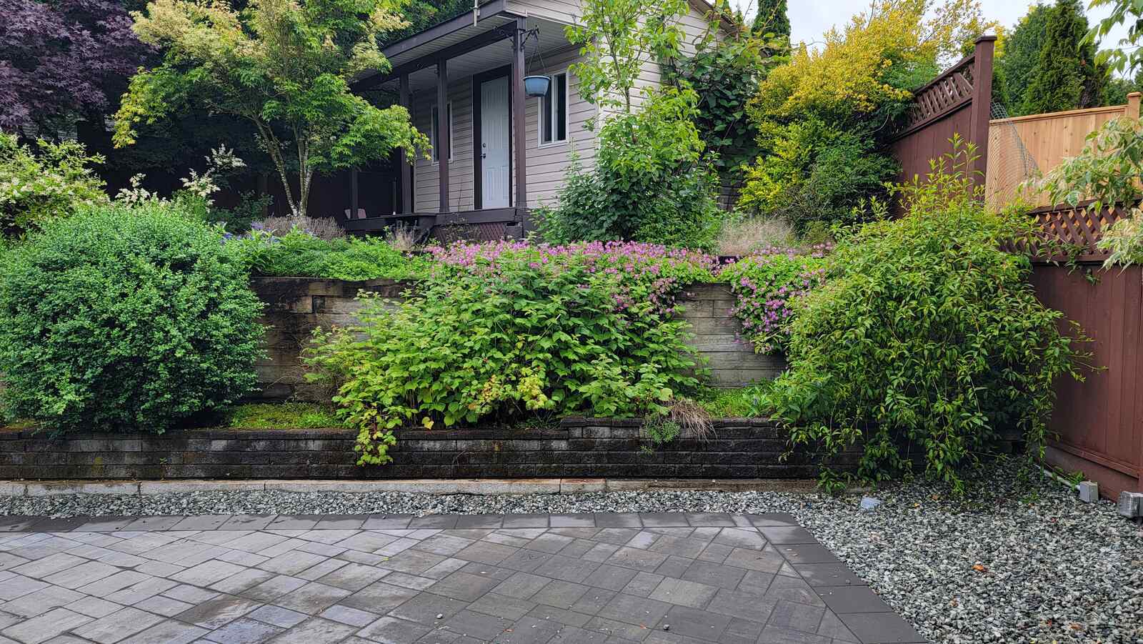 2_completed-retaining-wall-with-colorful-shrubs-and-landscaped-yard-back40-landscaping-langley-bc