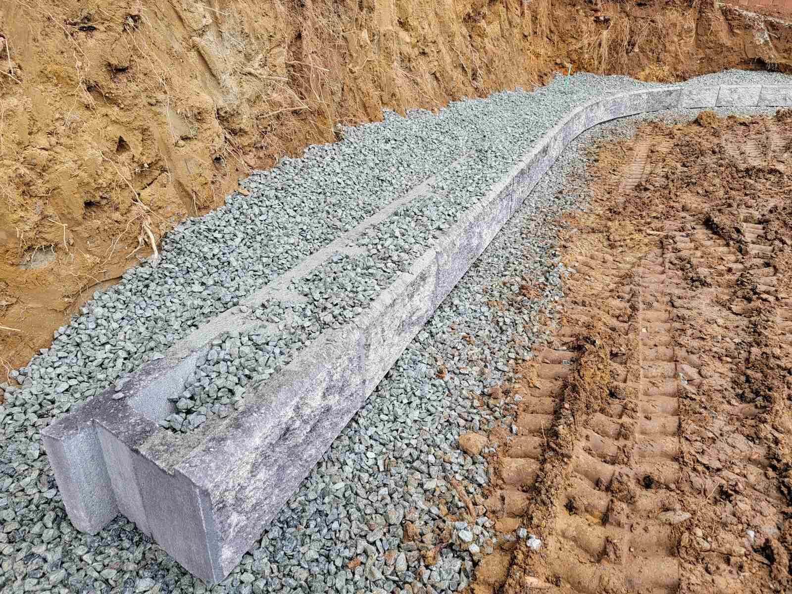 14_Curved retaining wall foundation with concrete blocks and gravel by Back40 Landscaping in Mission, BC