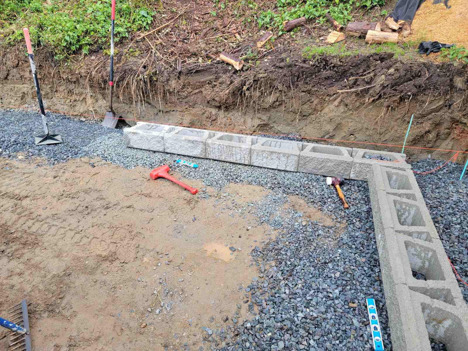 10_Close-up of retaining wall blocks and tools during construction by Back40 Landscaping in Mission, BC