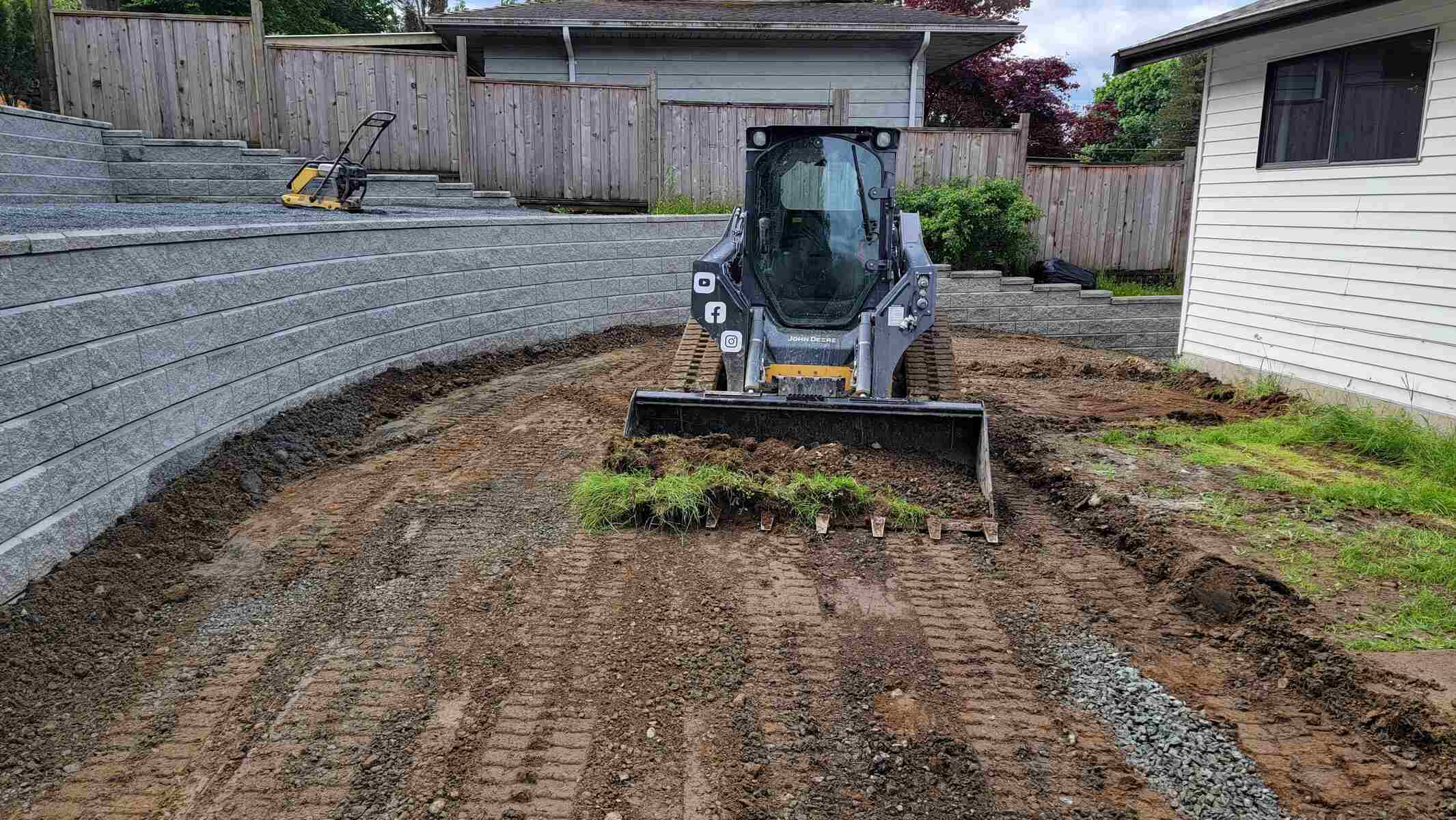 12_Compact loader clearing the ground near a retaining wall by Back40 Landscaping in Mission, BC