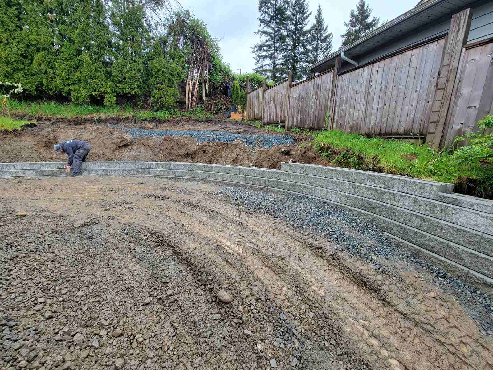 7_Worker finalizing a curved retaining wall project by Back40 Landscaping in Mission, BC