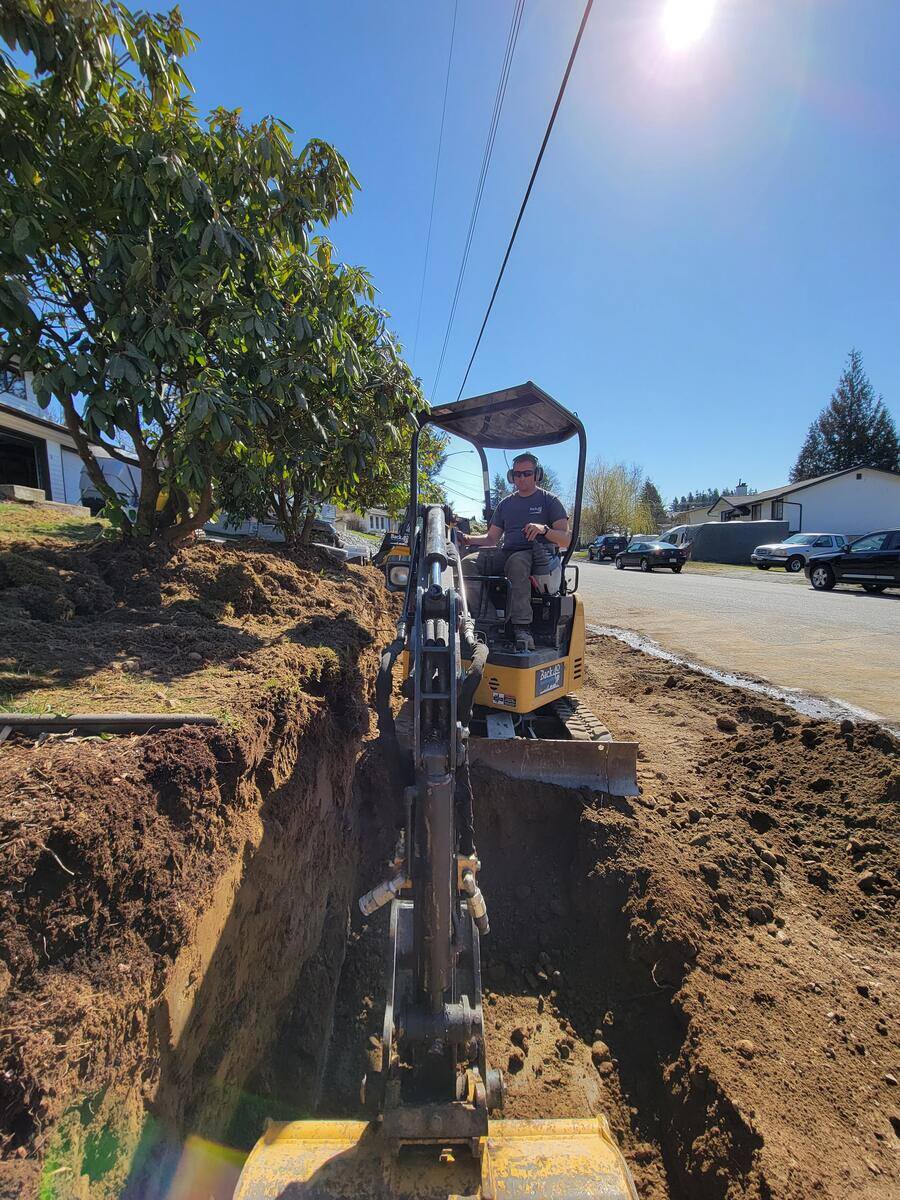 8_Excavator digging a trench for a retaining wall installation in Mission, BC, managed by Back40 Landscaping