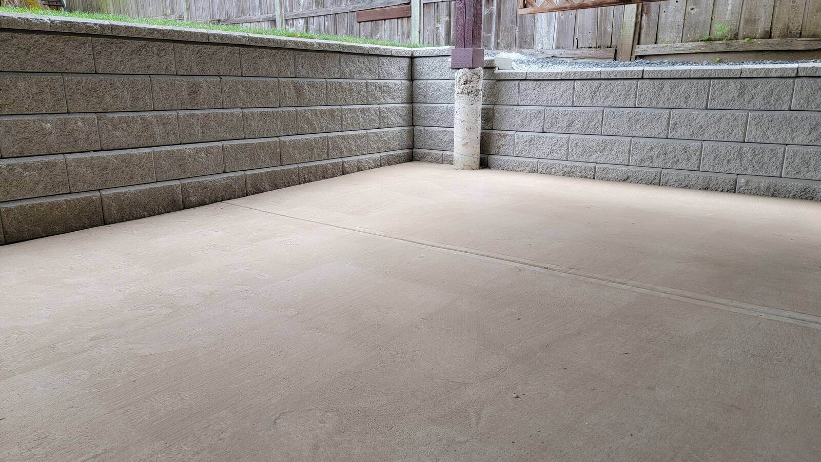 Concrete patio bordered by retaining wall, part of a landscaping project by Back 40 Landscaping in Mission, BC