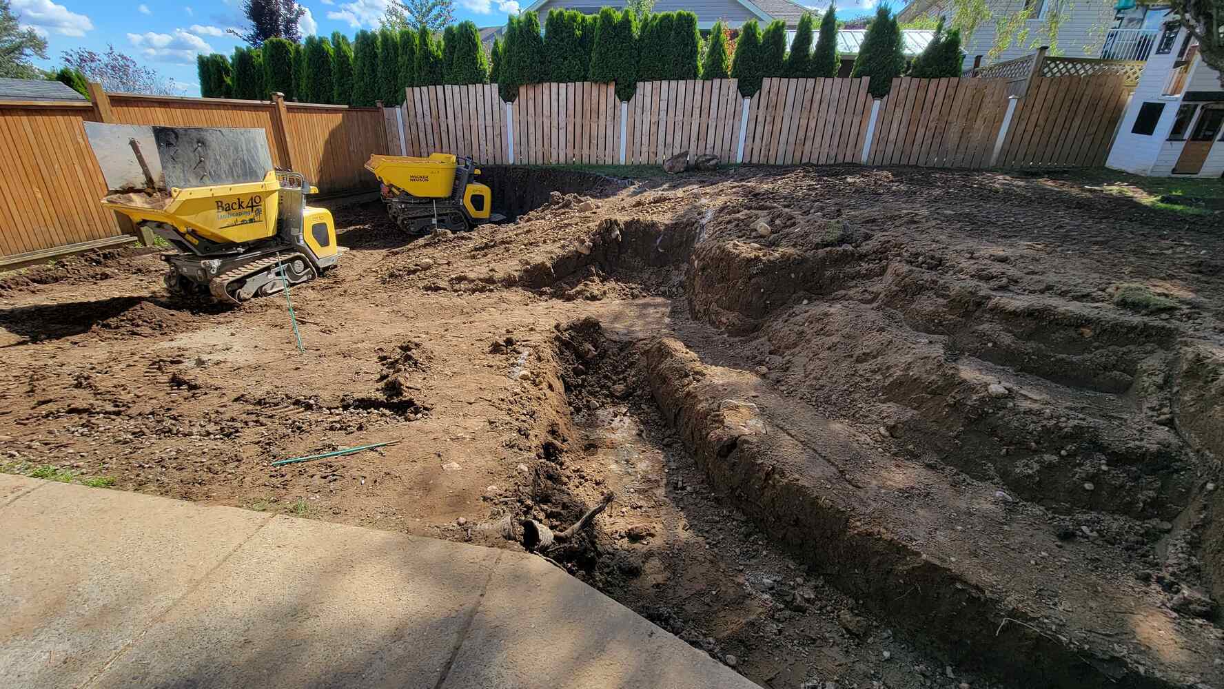 6_Excavated backyard with machinery for retaining wall construction by Back40 Landscaping in Mission, BC