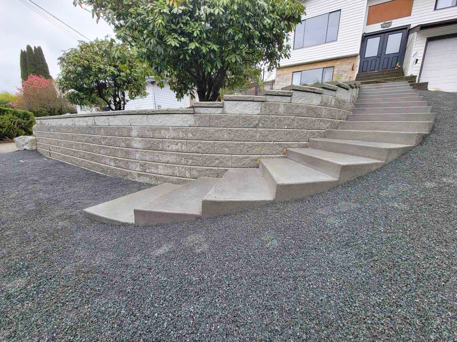 Concrete stairway and retaining wall on gravel slope by Back 40 Landscaping in Abbotsford, BC