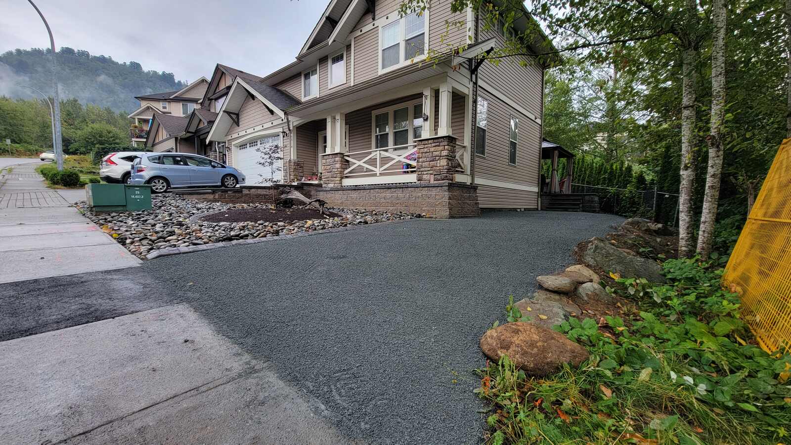 Freshly landscaped driveway with river rock edging by Back 40 Landscaping, Chilliwack, BC