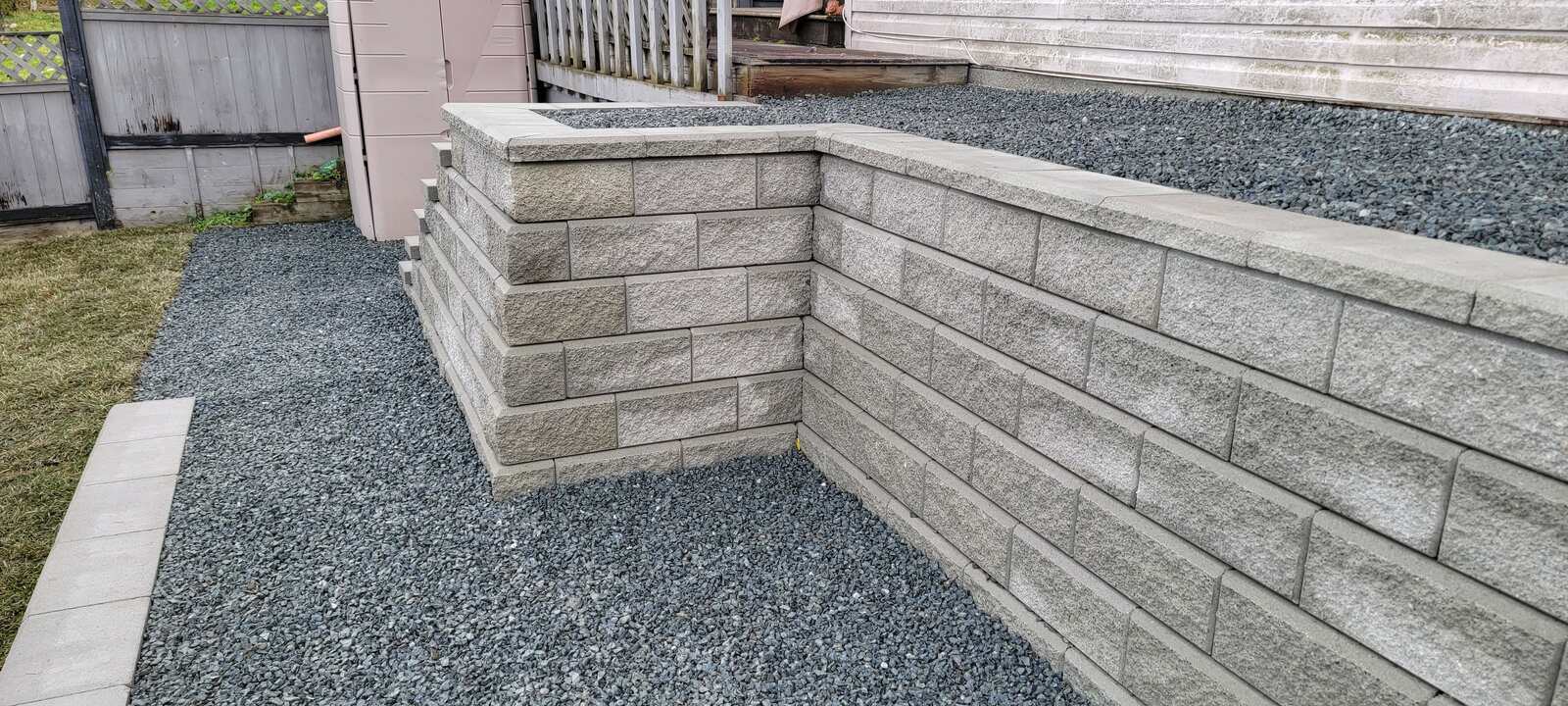 Side view of layered retaining wall construction with gravel base by Back 40 Landscaping, Chilliwack, BC