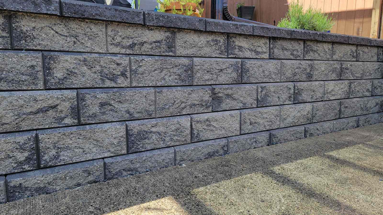 Backyard retaining wall with concrete blocks in Langley, BC by Back 40 Landscaping