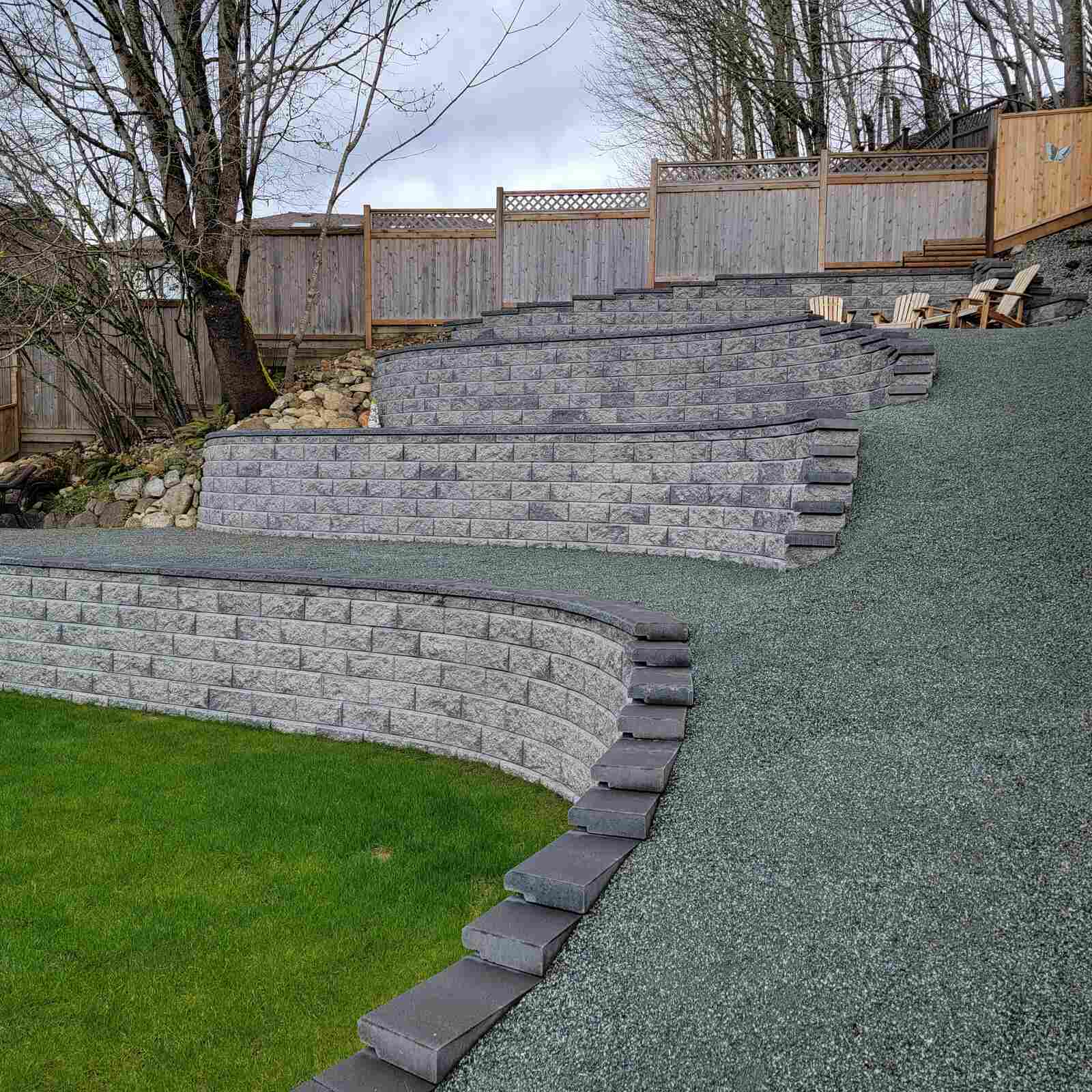 Curved pathway alongside a four-tier retaining wall in Langley, BC by Back 40 Landscaping