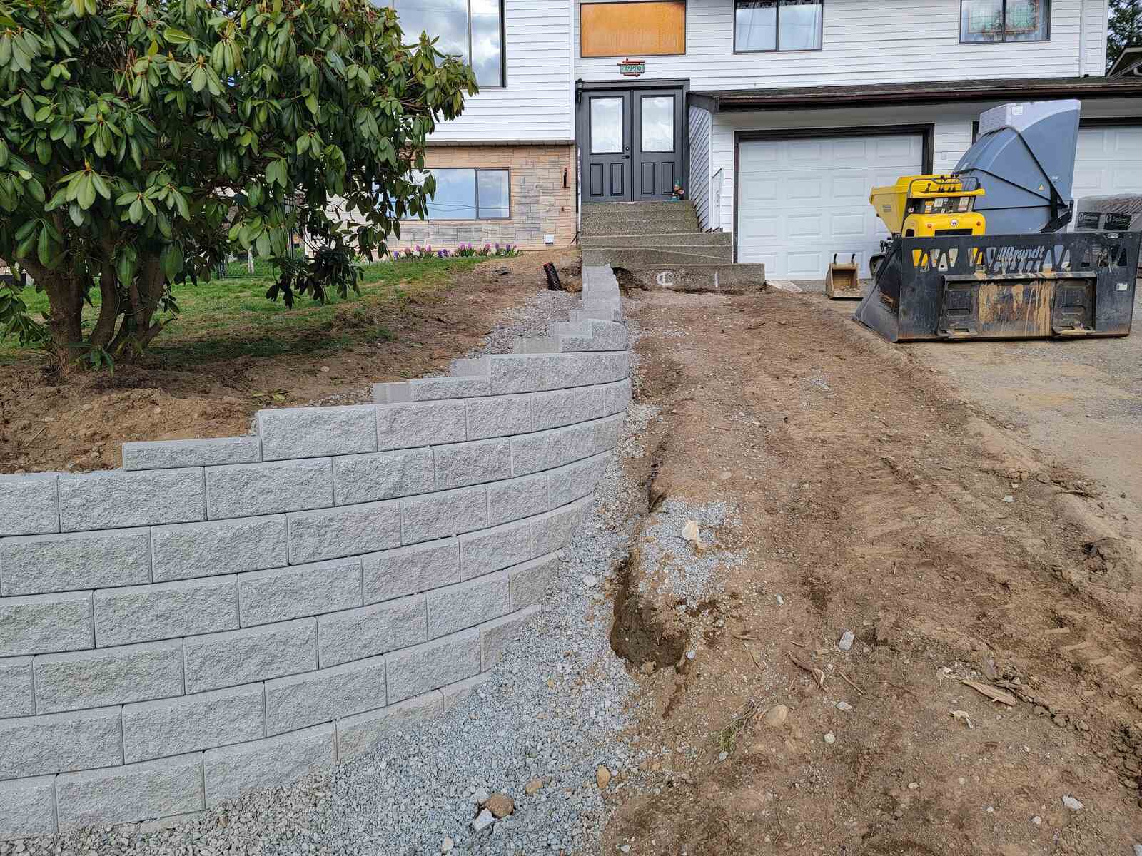 Partially constructed retaining wall by Back 40 Landscaping in Mission, BC, showing foundation details