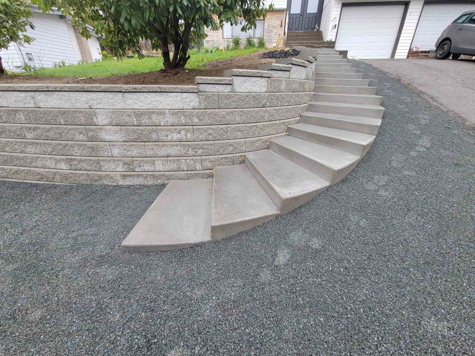 Stepped concrete pathway leading to retaining wall by Back 40 Landscaping in Mission, BC