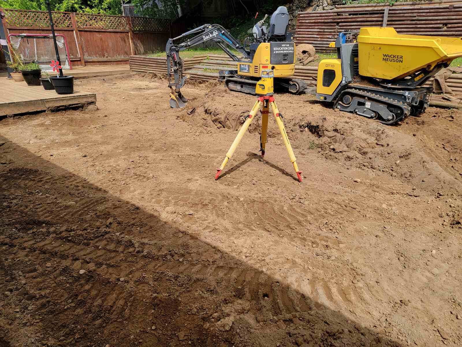 Ground preparation for landscaping in Abbotsford, BC, with surveying equipment set up by Back 40 Landscaping