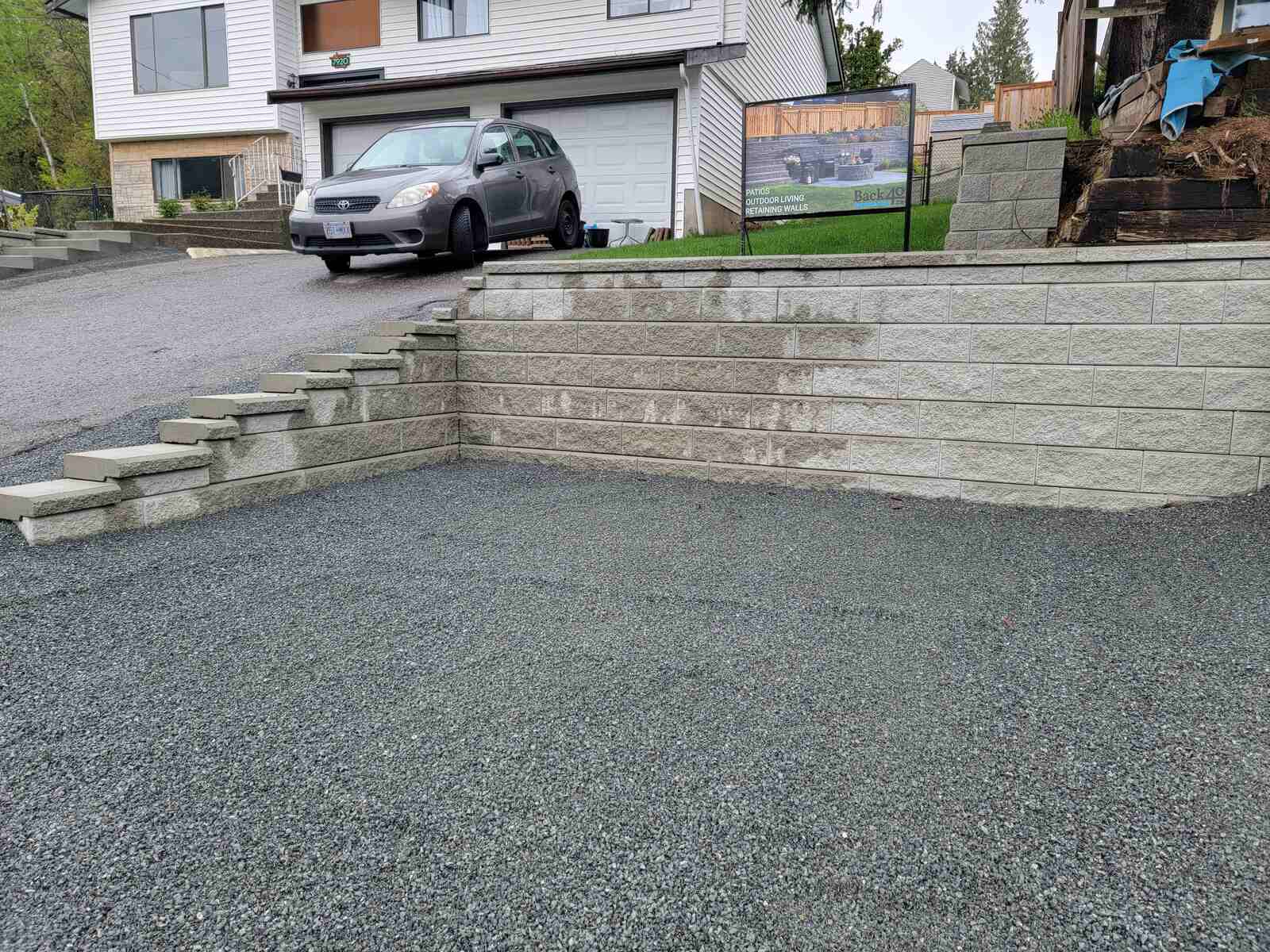 Multi-layered retaining wall with gravel by Back 40 Landscaping in Abbotsford, BC, enhancing property support and style