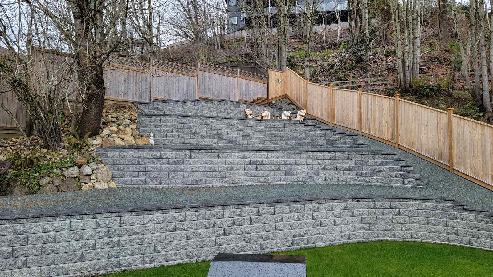 Tiered retaining wall and fence with patio seating area by Back 40 Landscaping in Abbotsford, BC